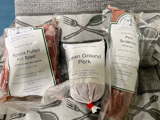 Three Carmen Corner Meats pork packages laid out side-by-side, Boneless Pulled Pork Roast, Lean Ground Pork and Pork Tenderloin.