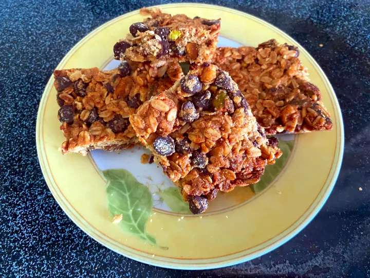 Freshly baked granola bars displayed on yellow green plate.