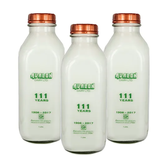 Three glass bottles of Goat's Milk stacked in a triangle shape