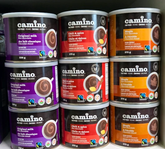 On display is a variety of Camino hot chocolate canisters stacked together forming three rows each with three high.