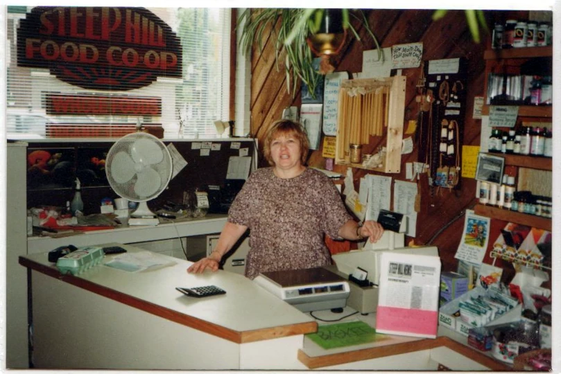 Gerry Yakimoski standing behind the counter by the cash register at Steep Hill Food Co-op store in Saskatoon, Saskatchewan.