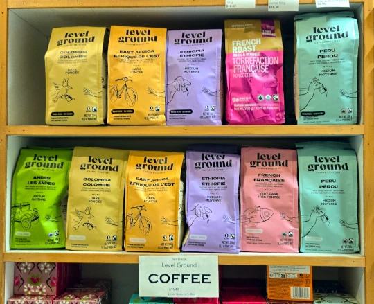 A shelf displaying the selection of multi coloured bags of fair trade Level Ground Coffee.