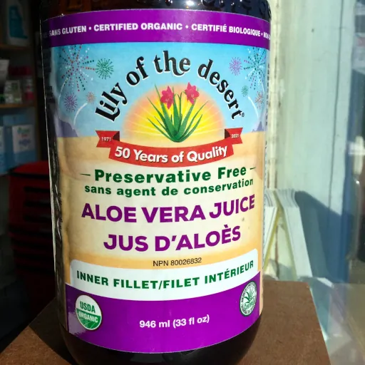 A jar glass of Lily of the Desert Aloe Vera Juice sitting on window sill