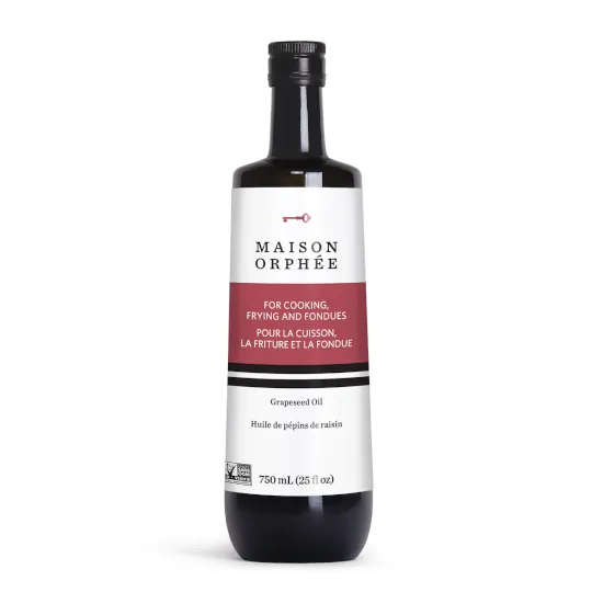 A glass bottle of grapeseed oil against a white background