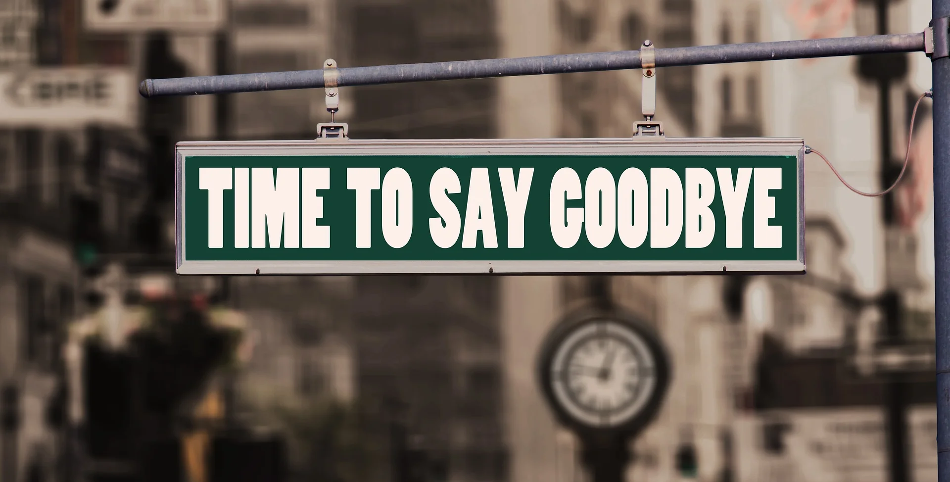 A sign is displayed on the street that reads, time to say goodbye.