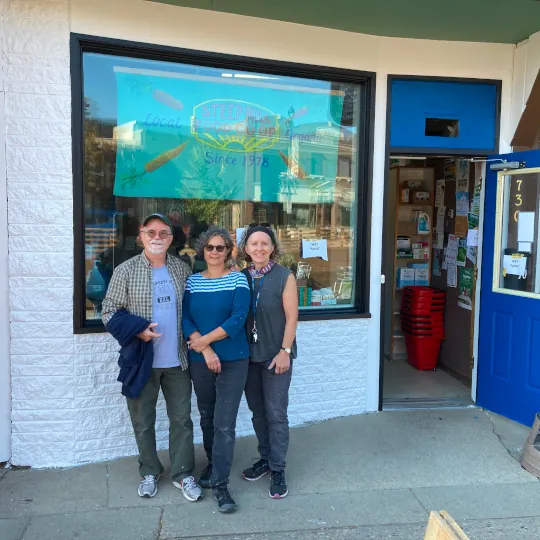 Store front with fresh white and blue paint and volunteers posing