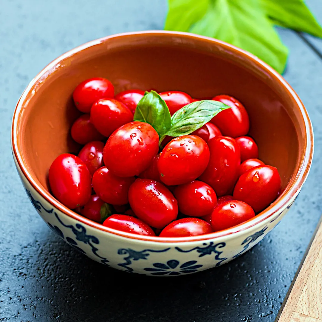 A bowl full of fresh grape tomatoes.