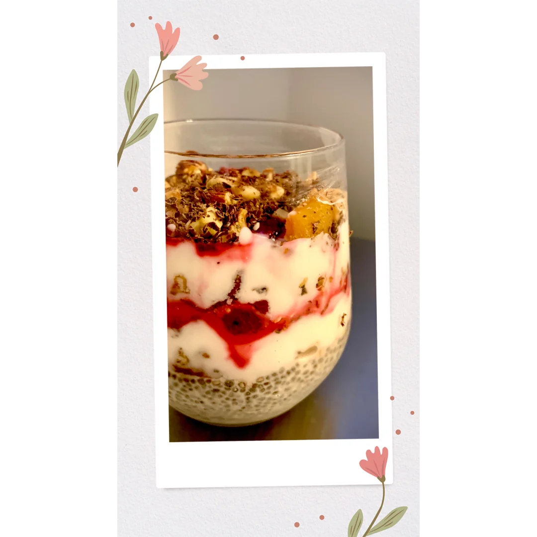 A side view of a clear glass that has been filled with five different layers that makes up Chia Pudding Parfait.
